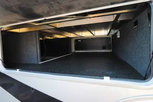 A large, carpeted pass-through storage area is available at the front of the RV.