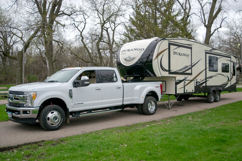White Ford truck pulling a Durango fifth wheel.