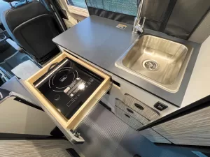 An induction cooktop stows in a galley drawer.