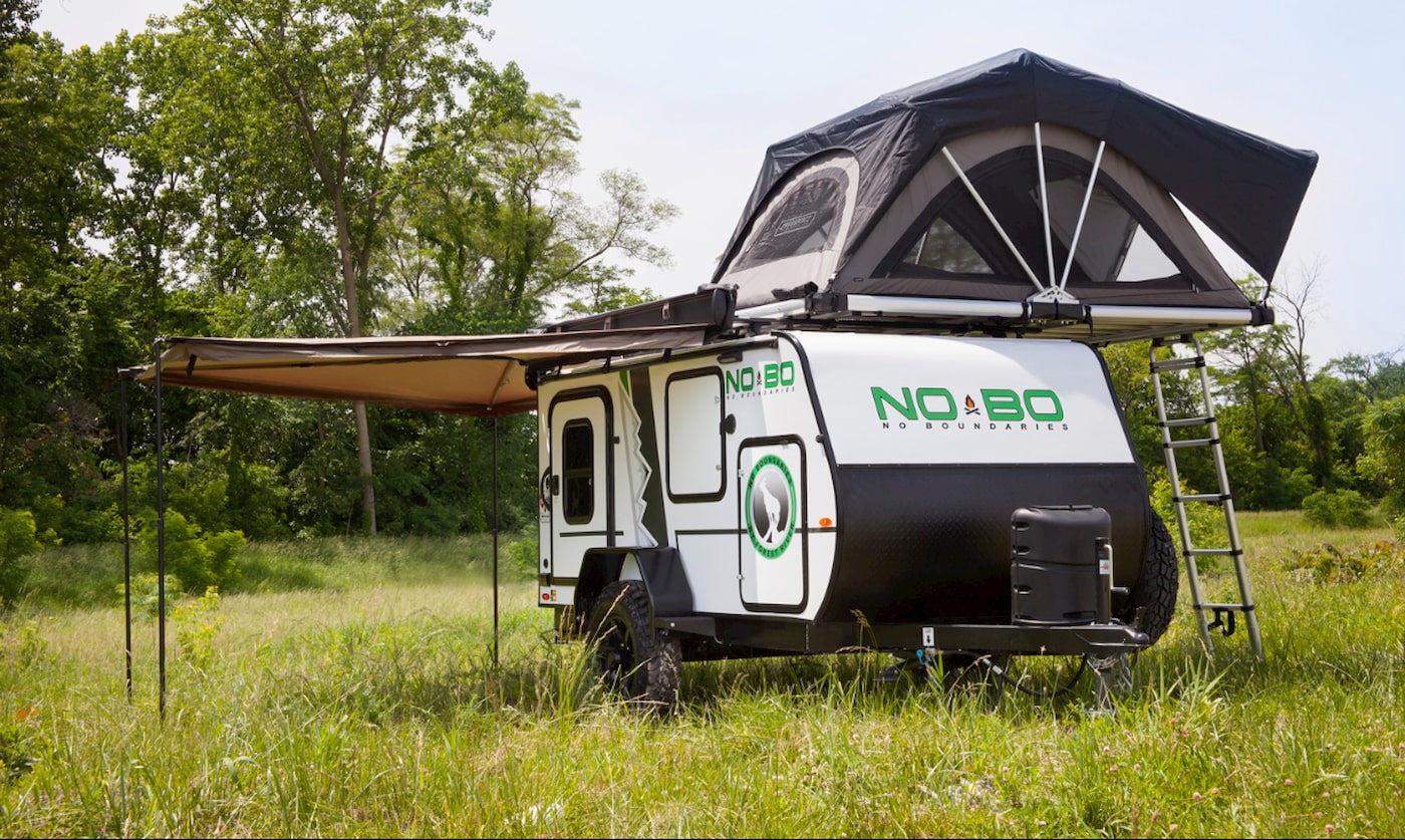 The nobo setup in a field with awning and rooftop tent
