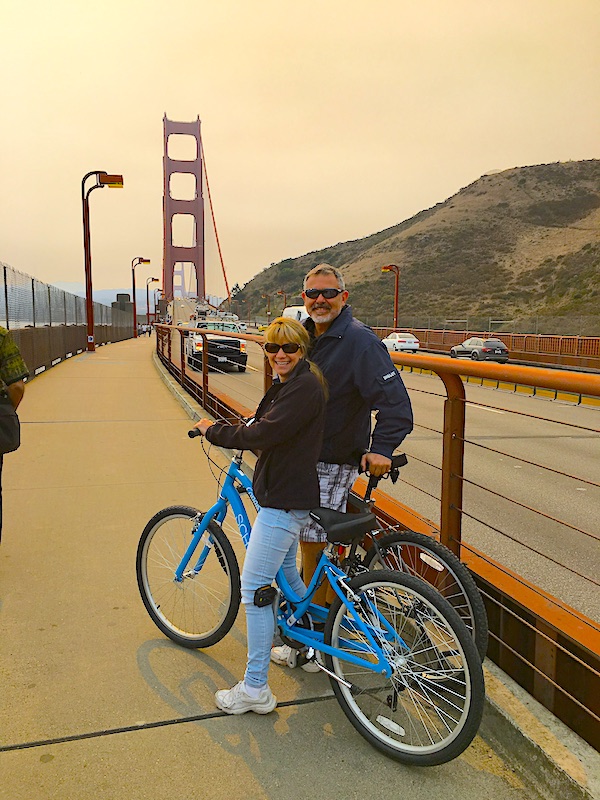 Mike and Susan riding bikes over the golden gate bridge in San Francisco