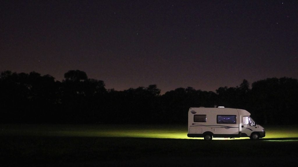RV parked in the forest at night.