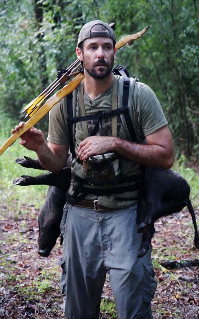 Man with a homemade bow hunting a pig