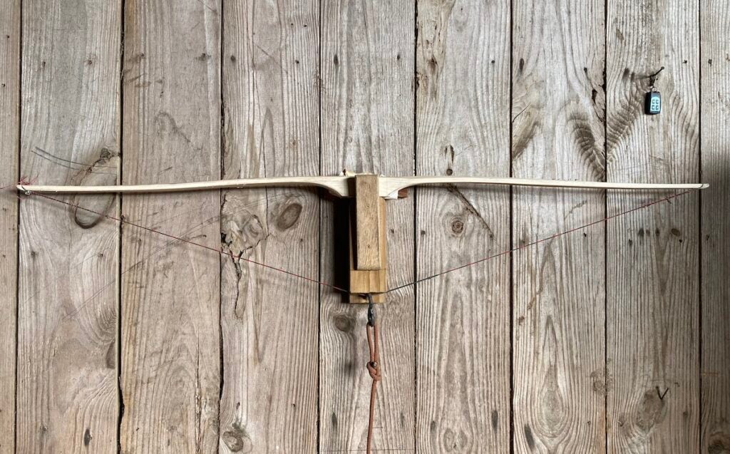 A wooden frame of a bow mounted on the wall