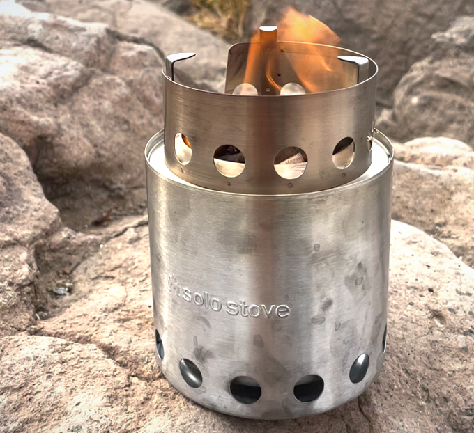 A small silver fire pit with a flame