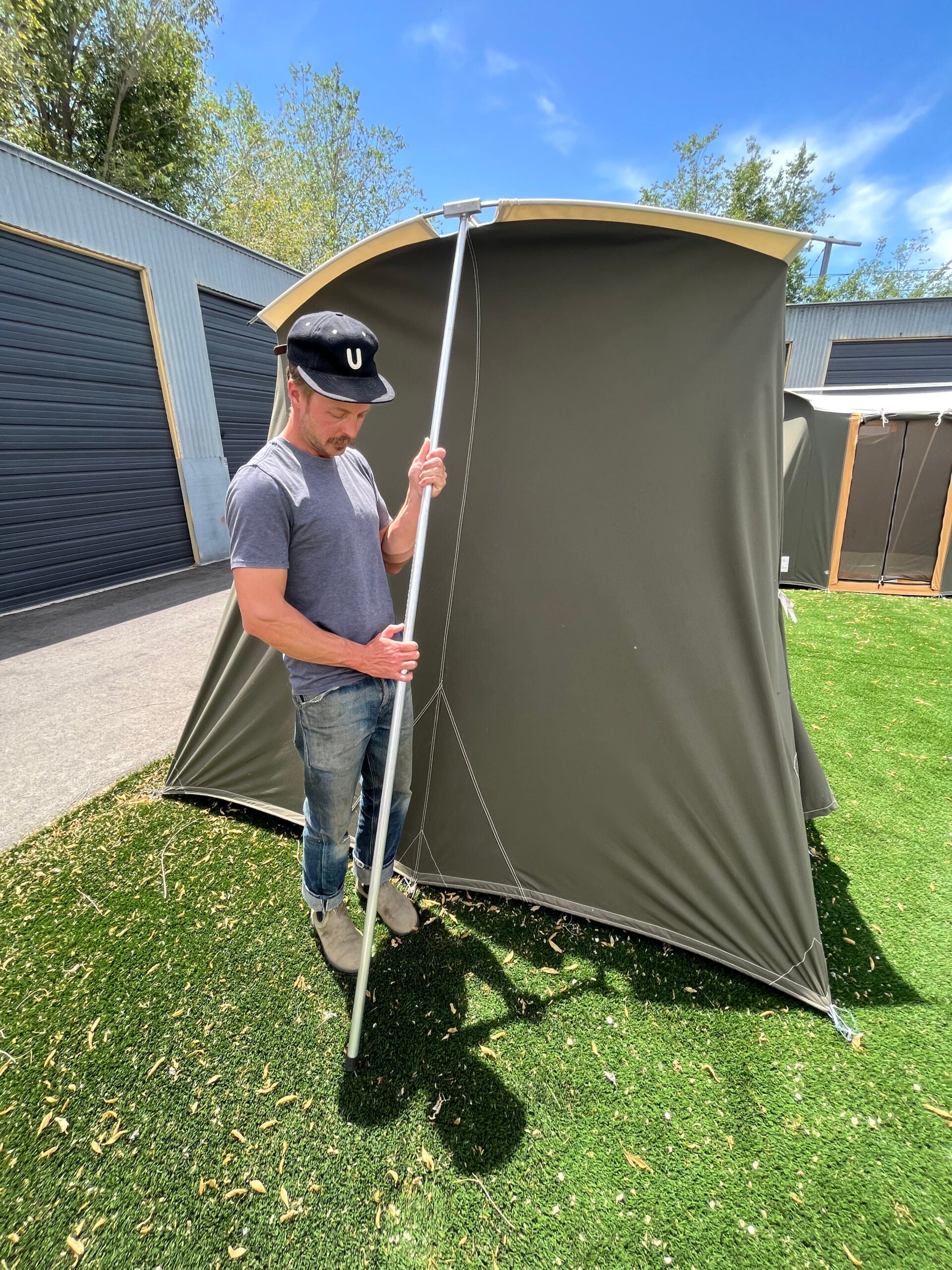 Man raises tent poles.