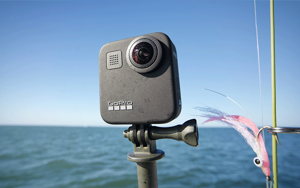 The Hero Max mounted on a tripod next to a fishing rod.