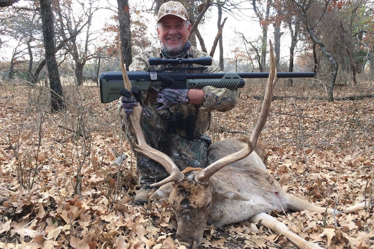 Author posing with shot animal and air rifle