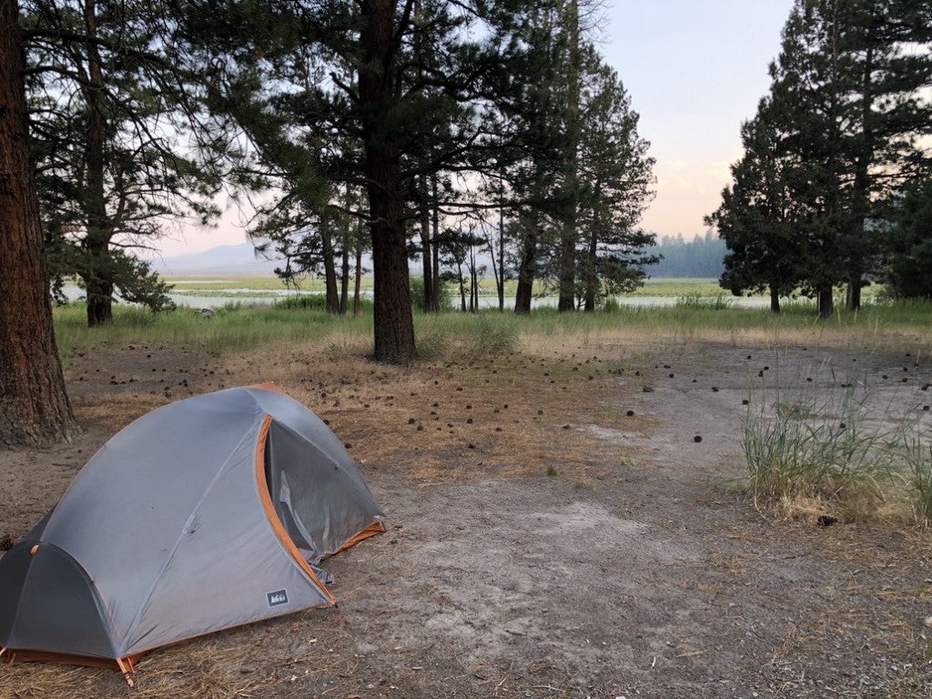 a grey tent set up on a free camping site in california near a lake