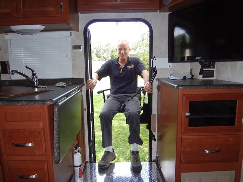 Man seated on CoachLift entering RV 