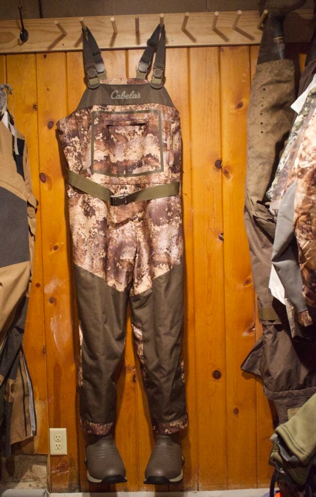 A pair of Cabela's waders hanging in a wood closet
