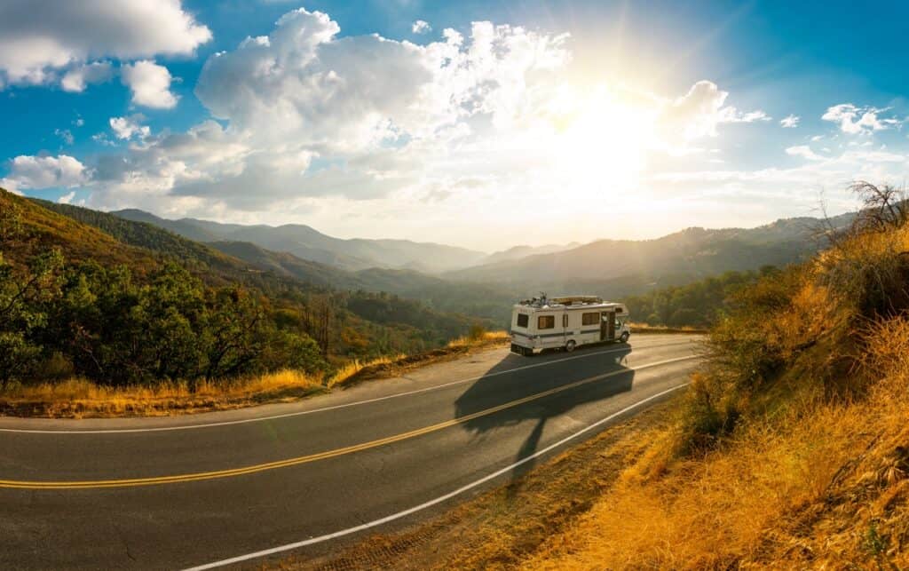 A Class C RV on the side of the road in a scenic location.