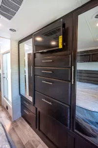 Dual mirrored bedroom closets flank an array of drawers, with more drawers below.