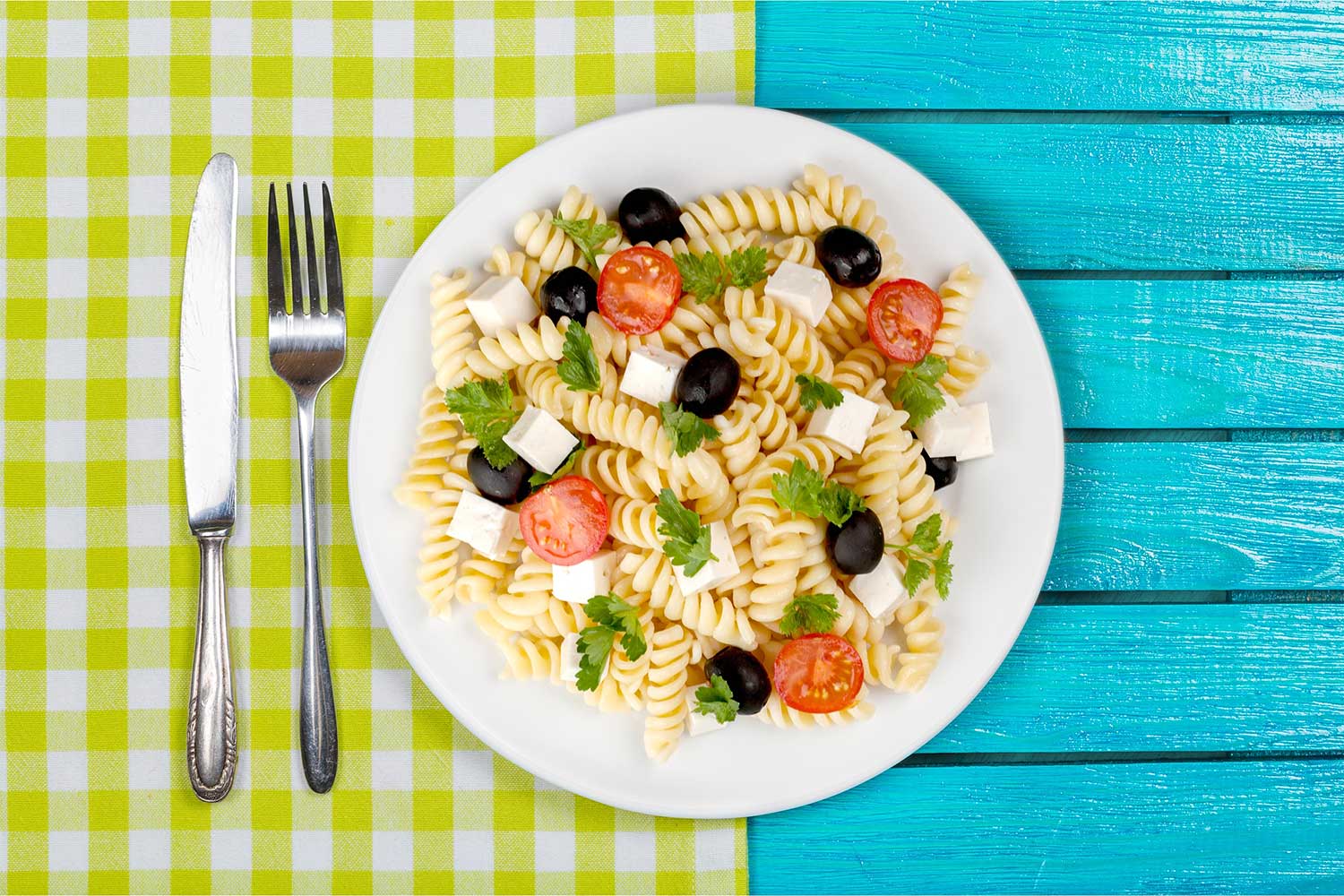 pasta salad on a blue and lime green picnic table 