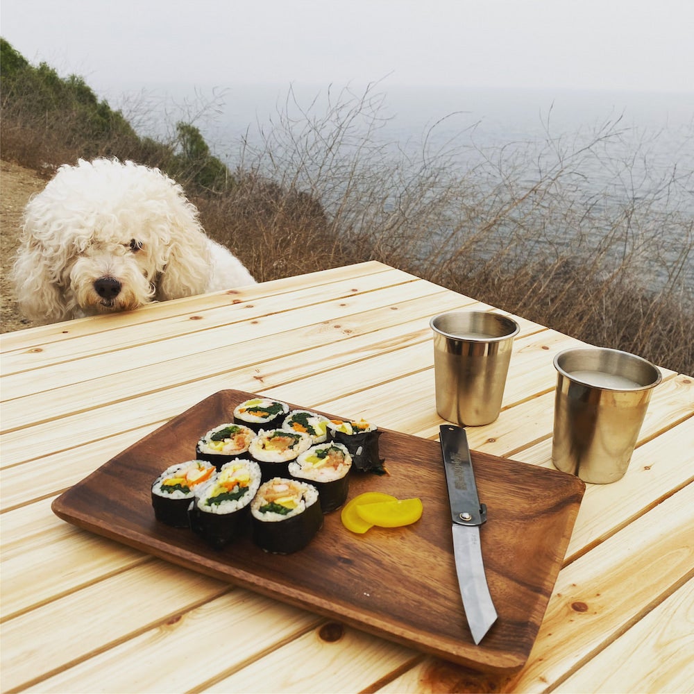 poodle looking at sushi on a table