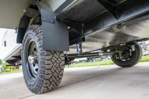 The RV includes an option package with 29-inch off-road tires, a wide-stance Dexter axle, galvanized steel fender liners, and stabilizer jacks.