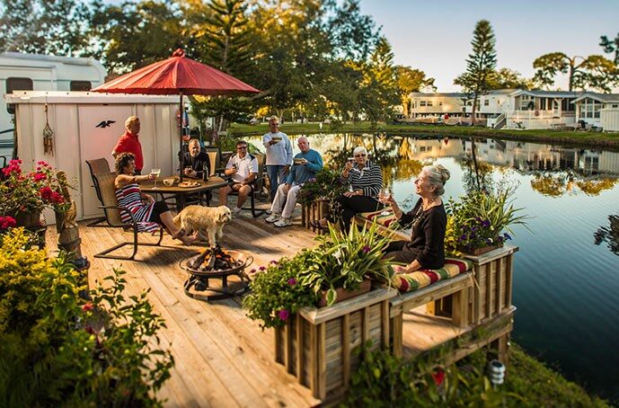 Seniors gathered on a lake side patio with RVs in the background - snowbird rentals
