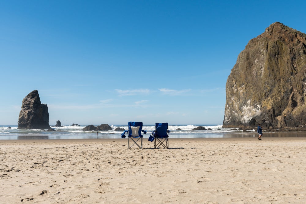 two beach chairs on the coast of oregon's cannon beach
