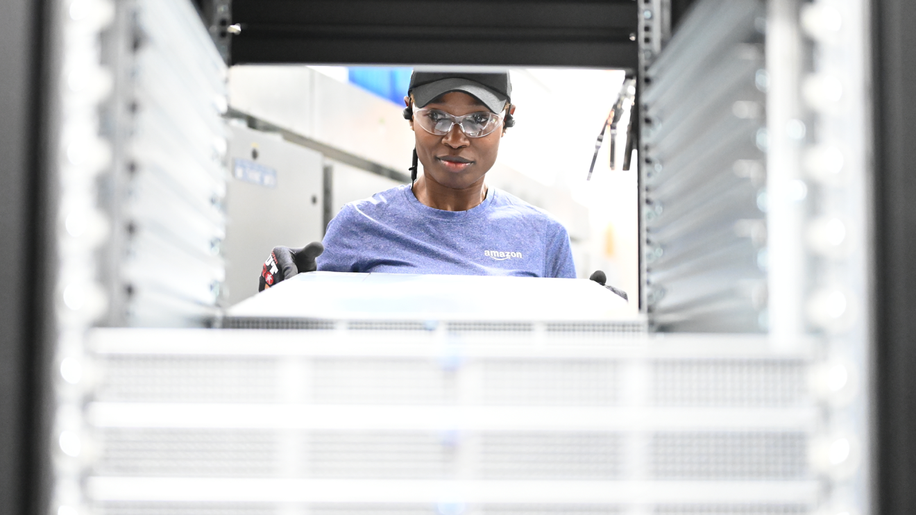 A photo of an employee holding server racks within a data center. 