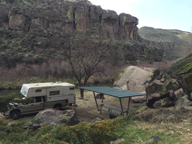 truck parked at campsite with canyon behind