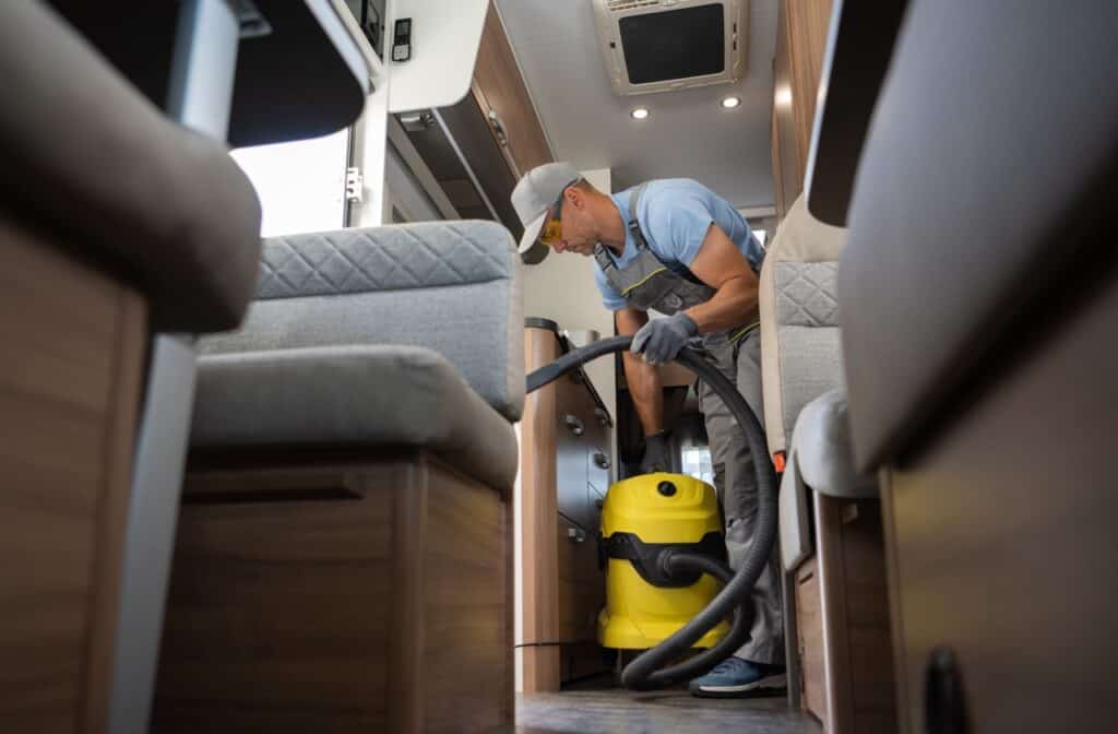 A man vacuuming the interior of his RV.