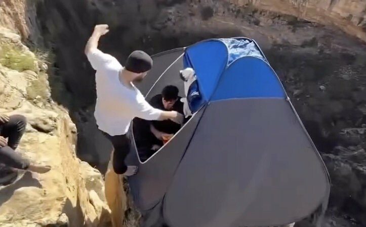 Two Guys Jump Off Cliff Into a Popup Tent for No Apparent Reason