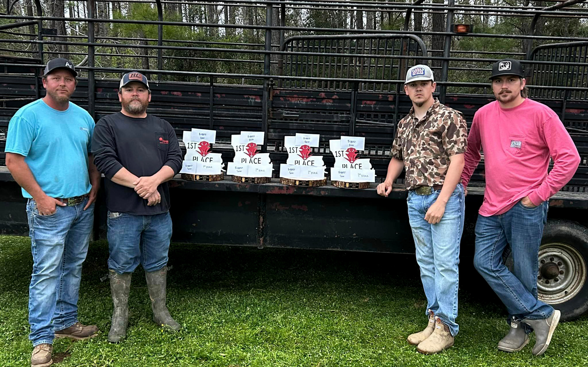 Men win first-place trophies in hog hunting contest.