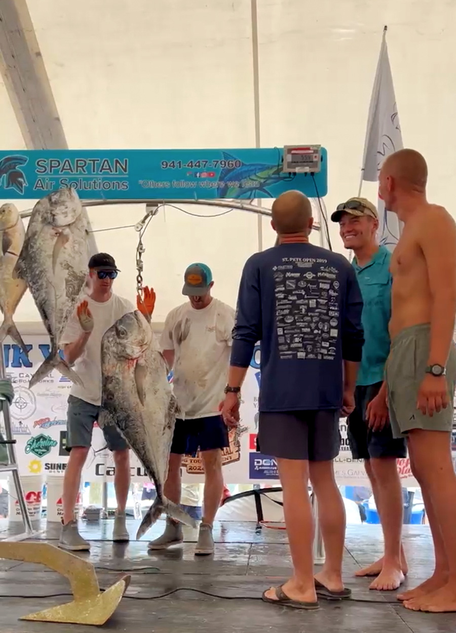 Weighing an African pompano at a spearfishing tournament.