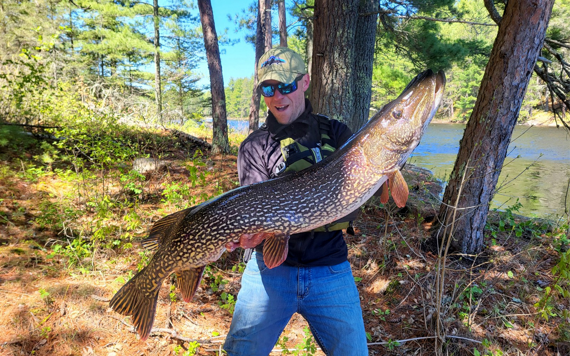 An angler eyes the huge pike he caught. 