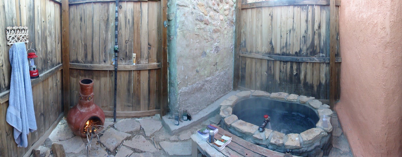 Closed in room with wooden doors and hot spring stone tub.