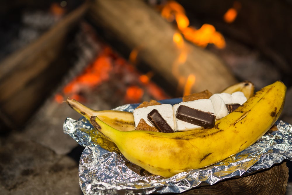 a stuffed banana on a campfire in tin foil