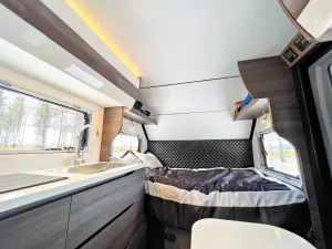 A full-size bed rests at the front of the X145. 