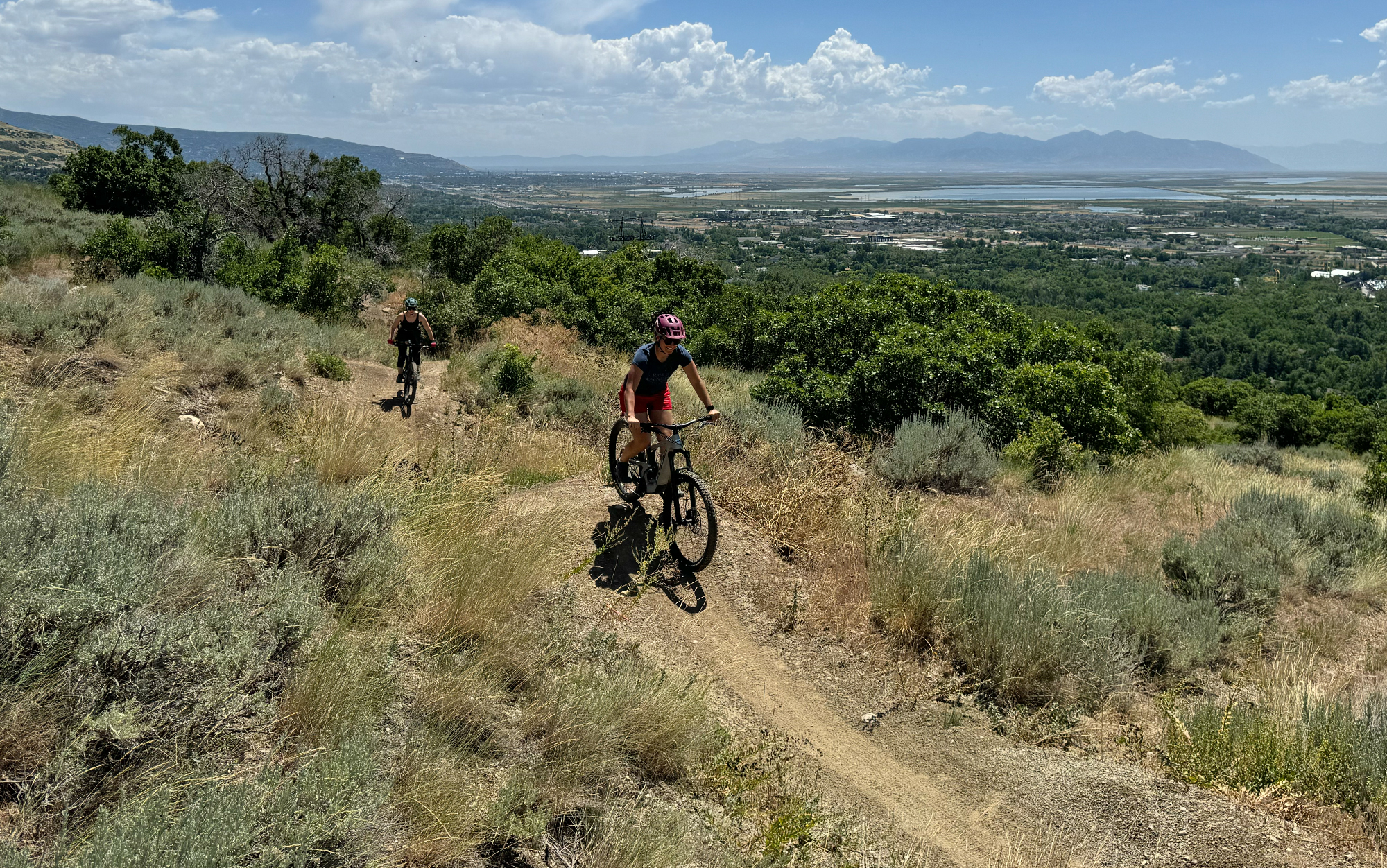 Taylor rides the Heckler and Hill rides the Stumpjumper through a jump line.