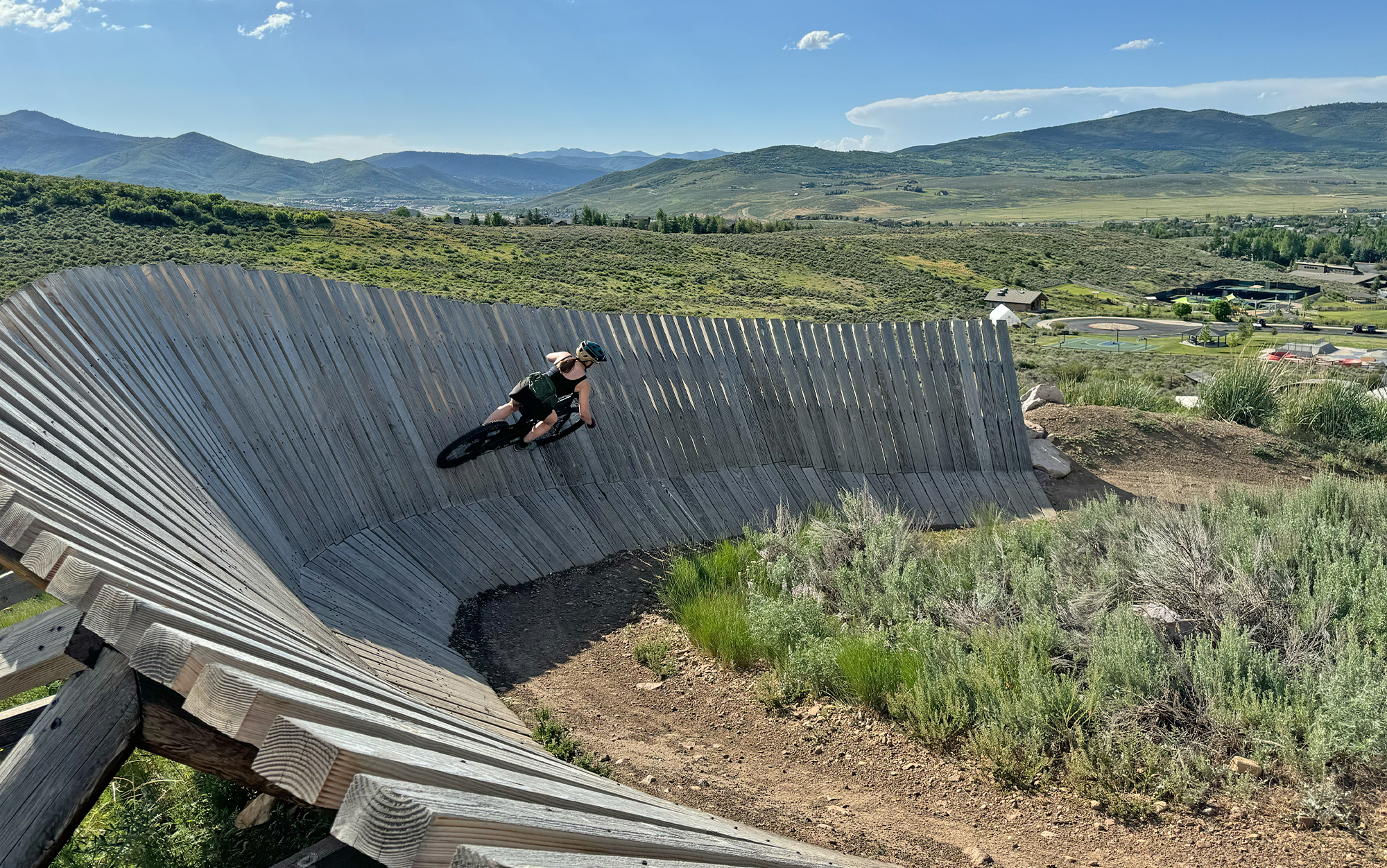 Biker rides wooden berm.