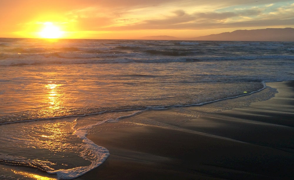  a panoramic shot of the pacific ocean from a california beach at sunset