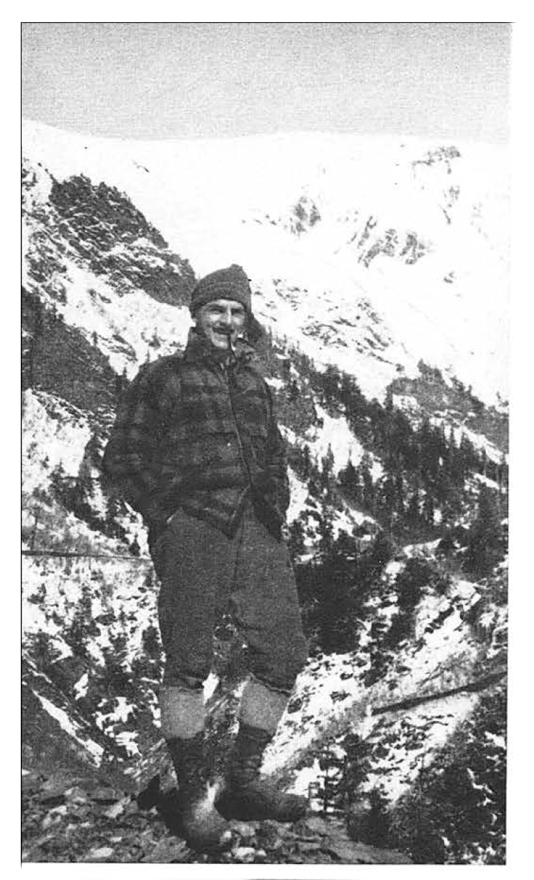 Anton Money, an Alaska mountain man, stands in the mountains in a black and white photo.