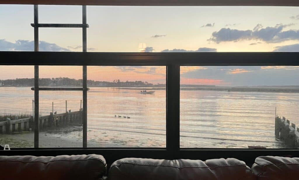 The view of the ocean through an RV's window at Tom's Cove Park.