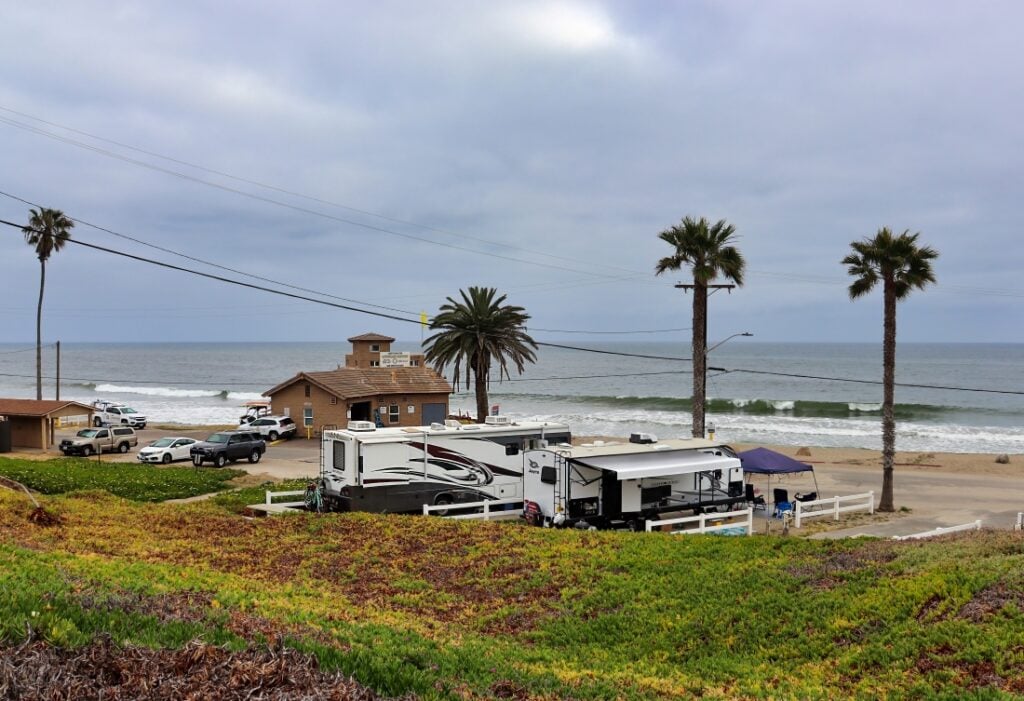 RVs at an oceanfront RV resort with palm trees.