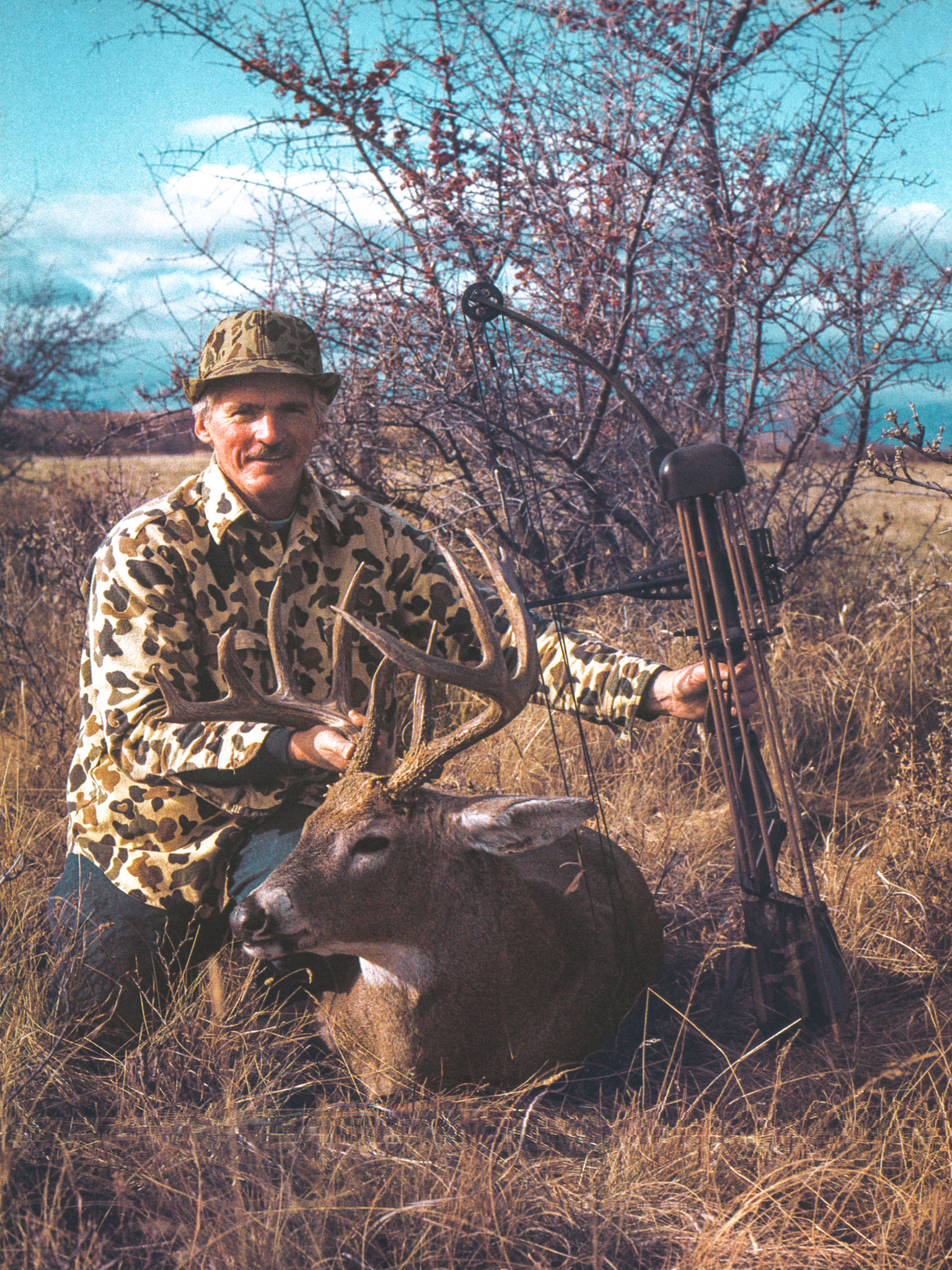 Bowhunter Bill McRae kneels beside a big buck he shot with his bow.