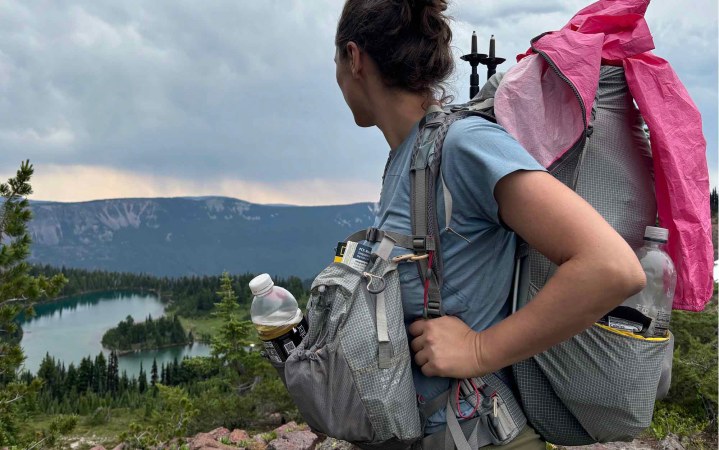  woman looking out at mountain ridge while wearing the Aarn Mountain Magic Pro backpack