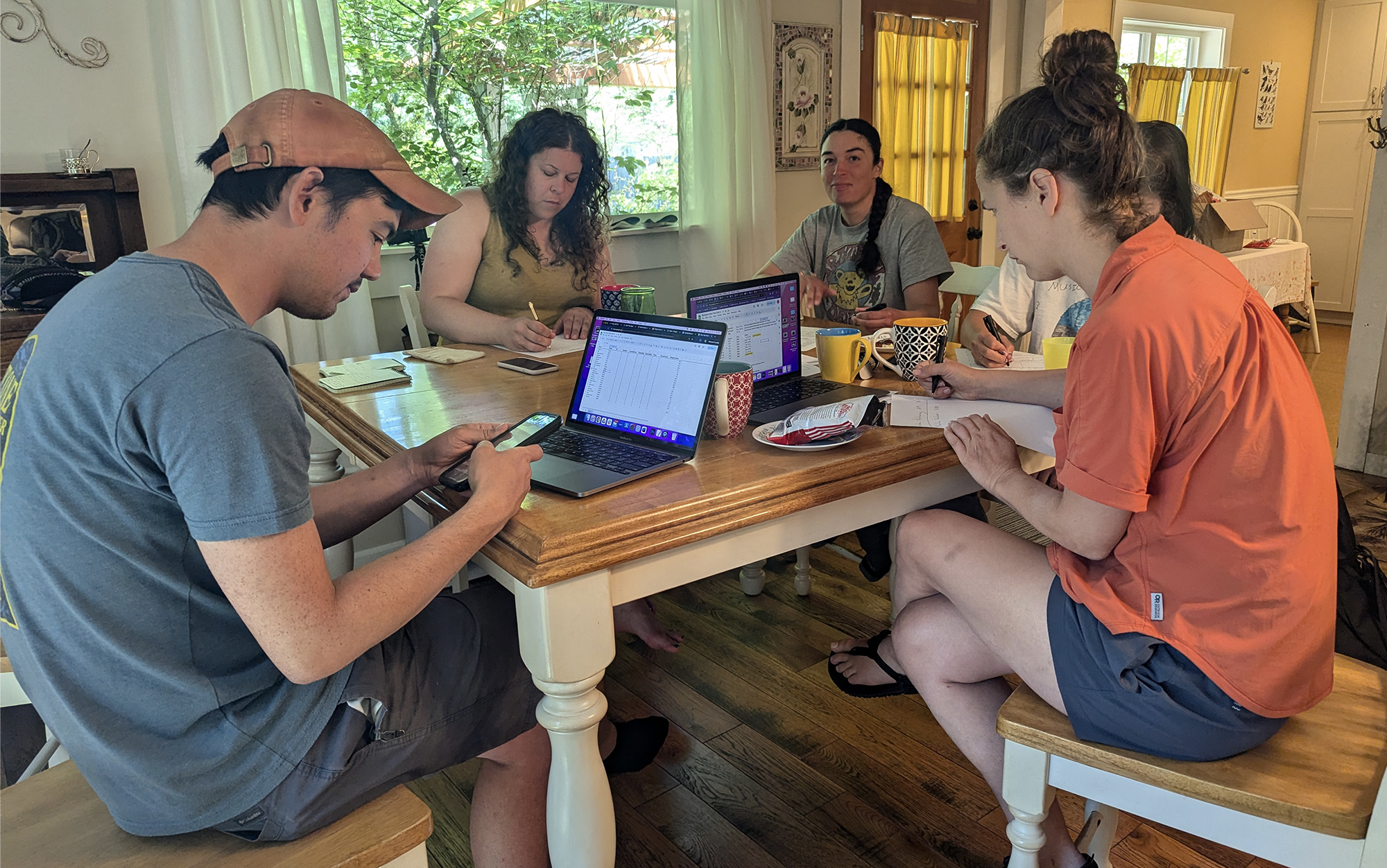 Five people sitting around a table filling out score sheets