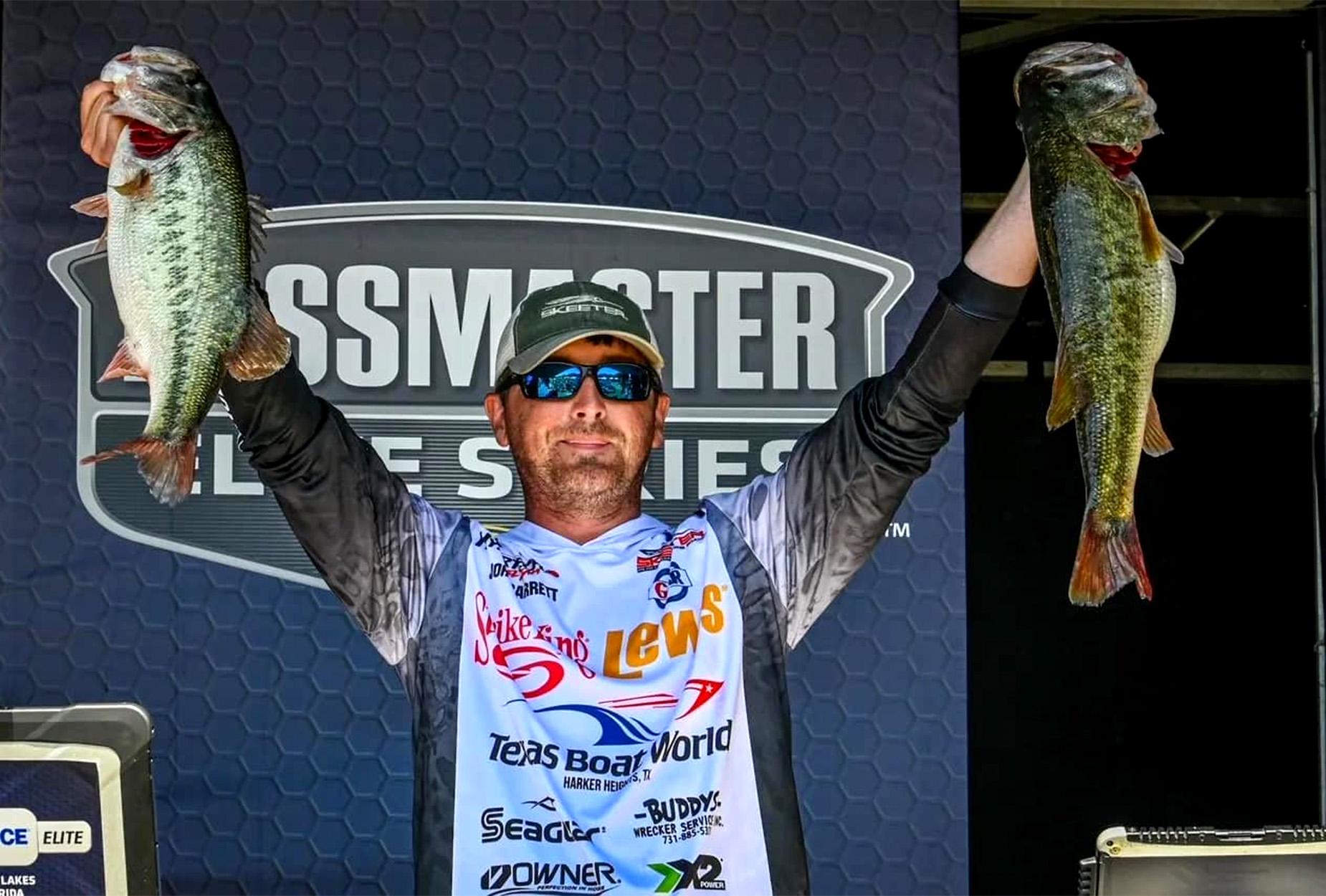 Bass pro John Garrett holds up two fish.