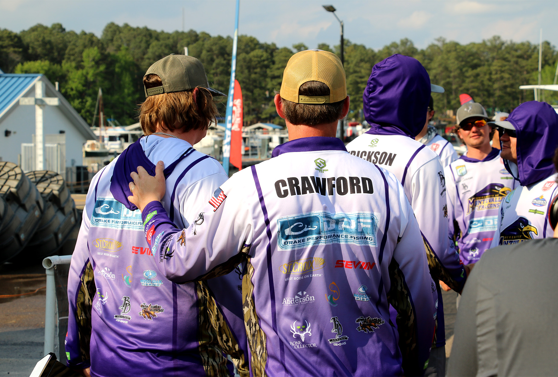 A college fishing coach and a student angler walk together.