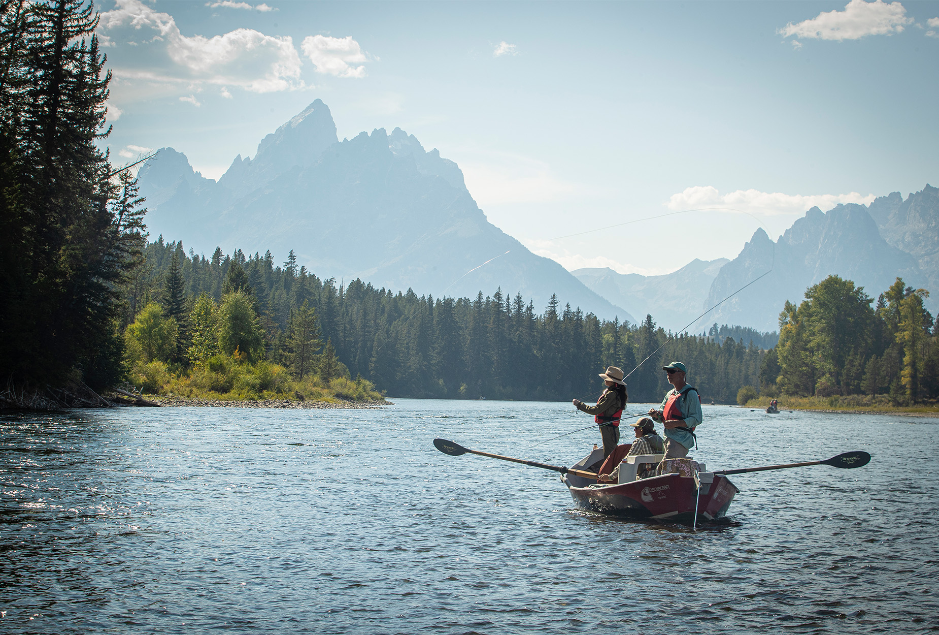 A drift boat with anglers floats down the Snake River.