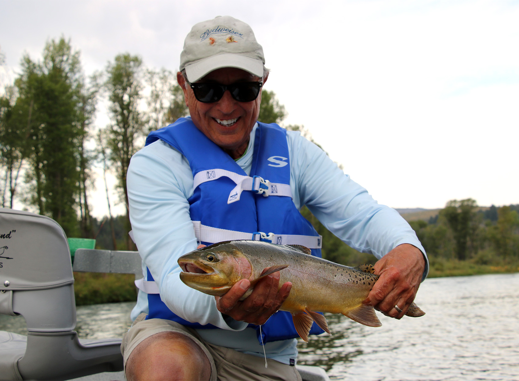 A fly angler holds up a nice cutbow.