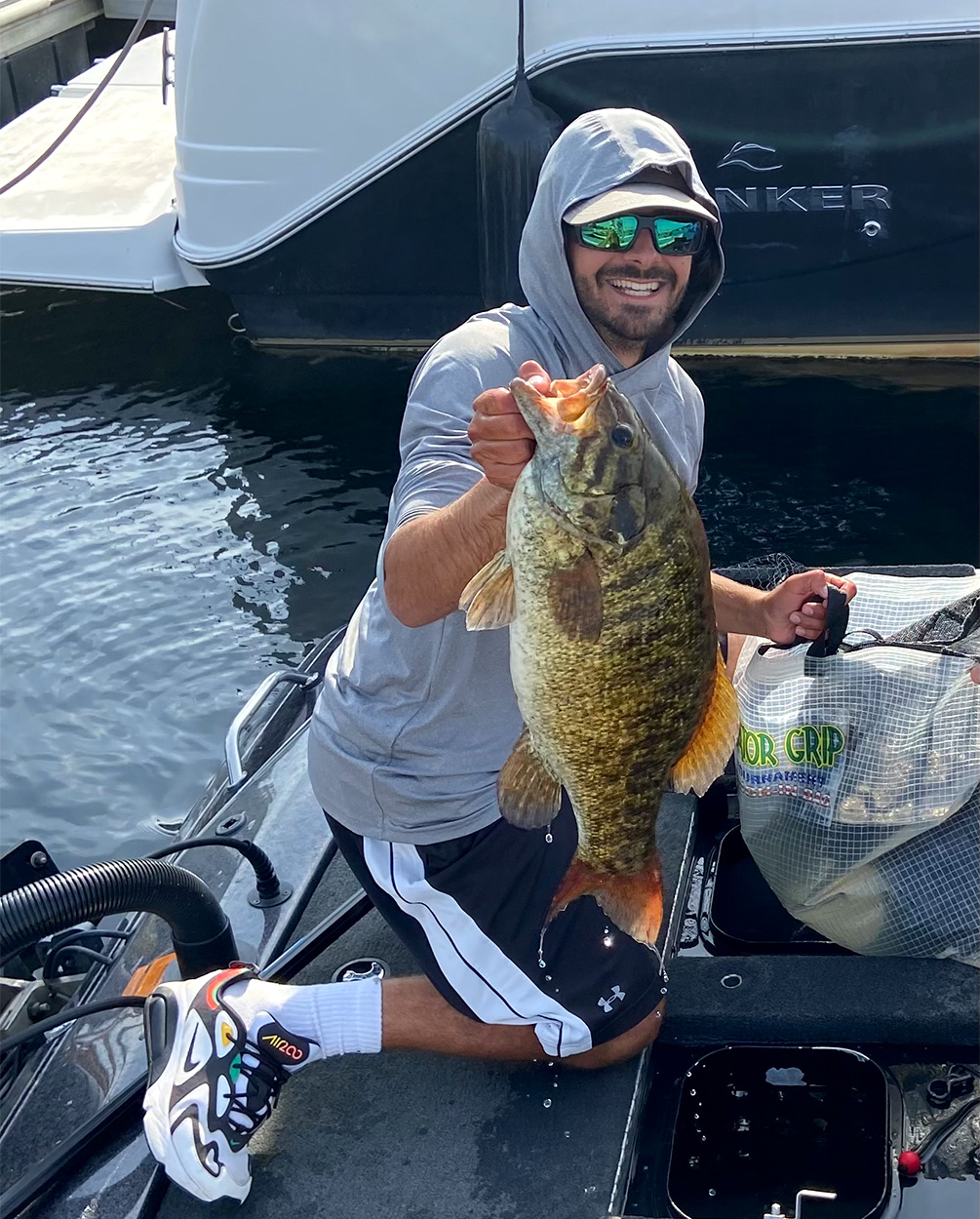 A tournament angler holds up a giant smallmouth bass.