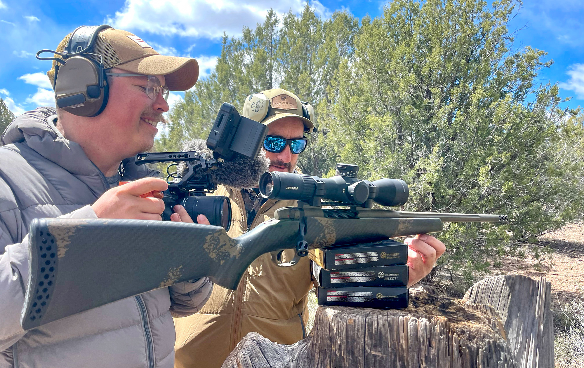 A camera guy records video of a rifle.