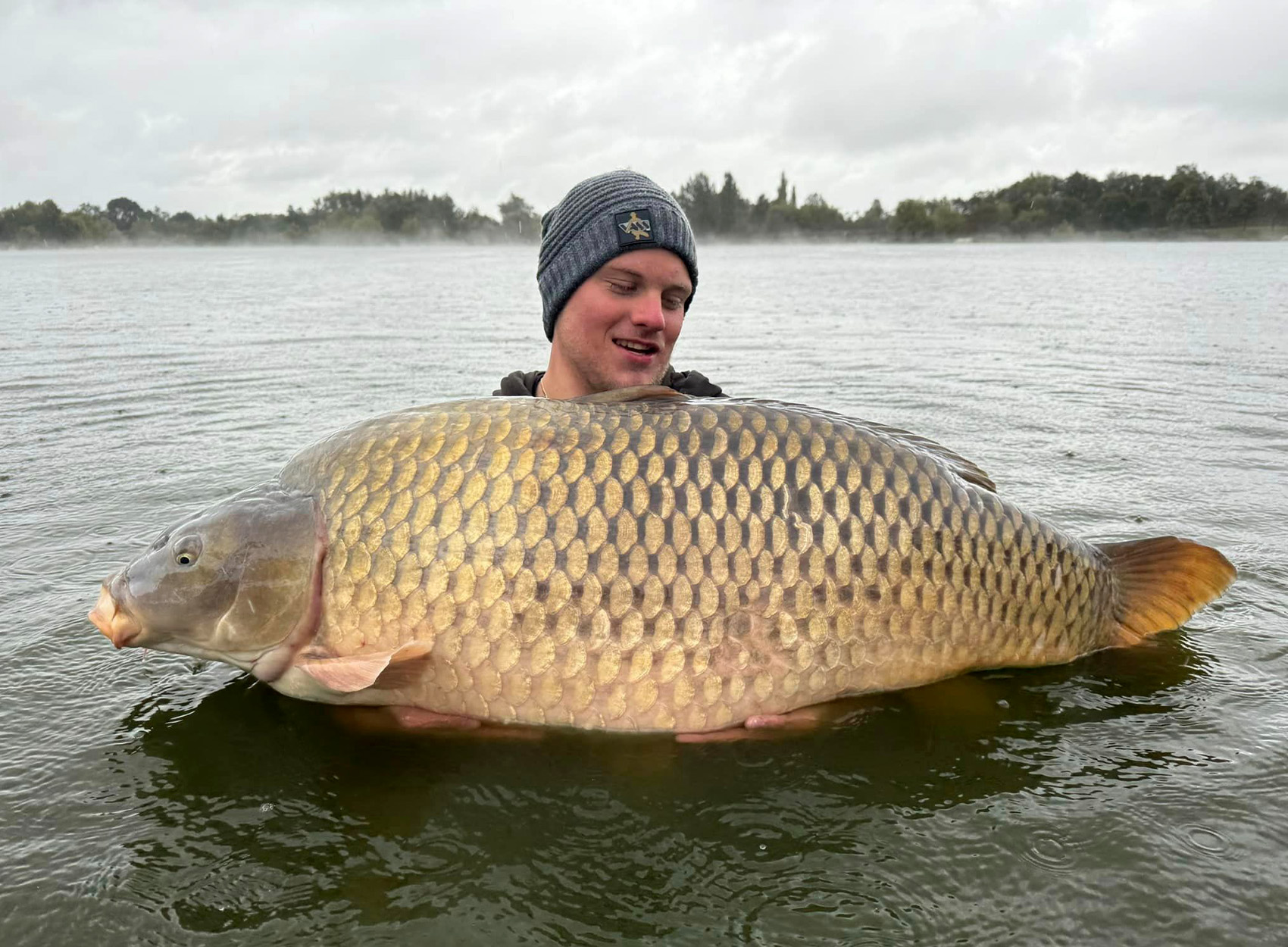 A Polish angler holds up a world-record-sized common carp.