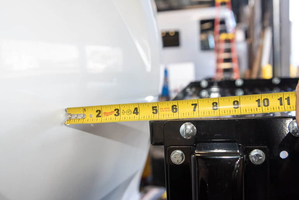 A tape measure showing two inches of clearance between the tray and the trailer.