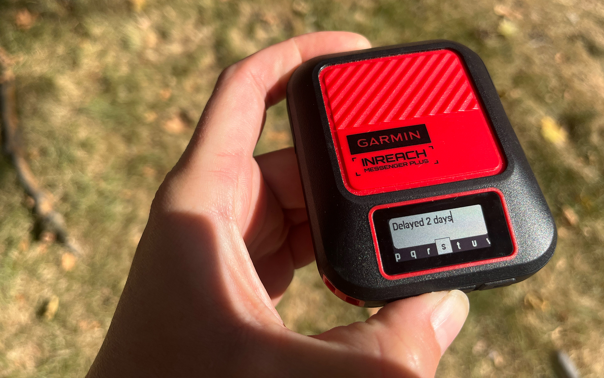 Hiker types out message on Garmin inReach Messenger device.